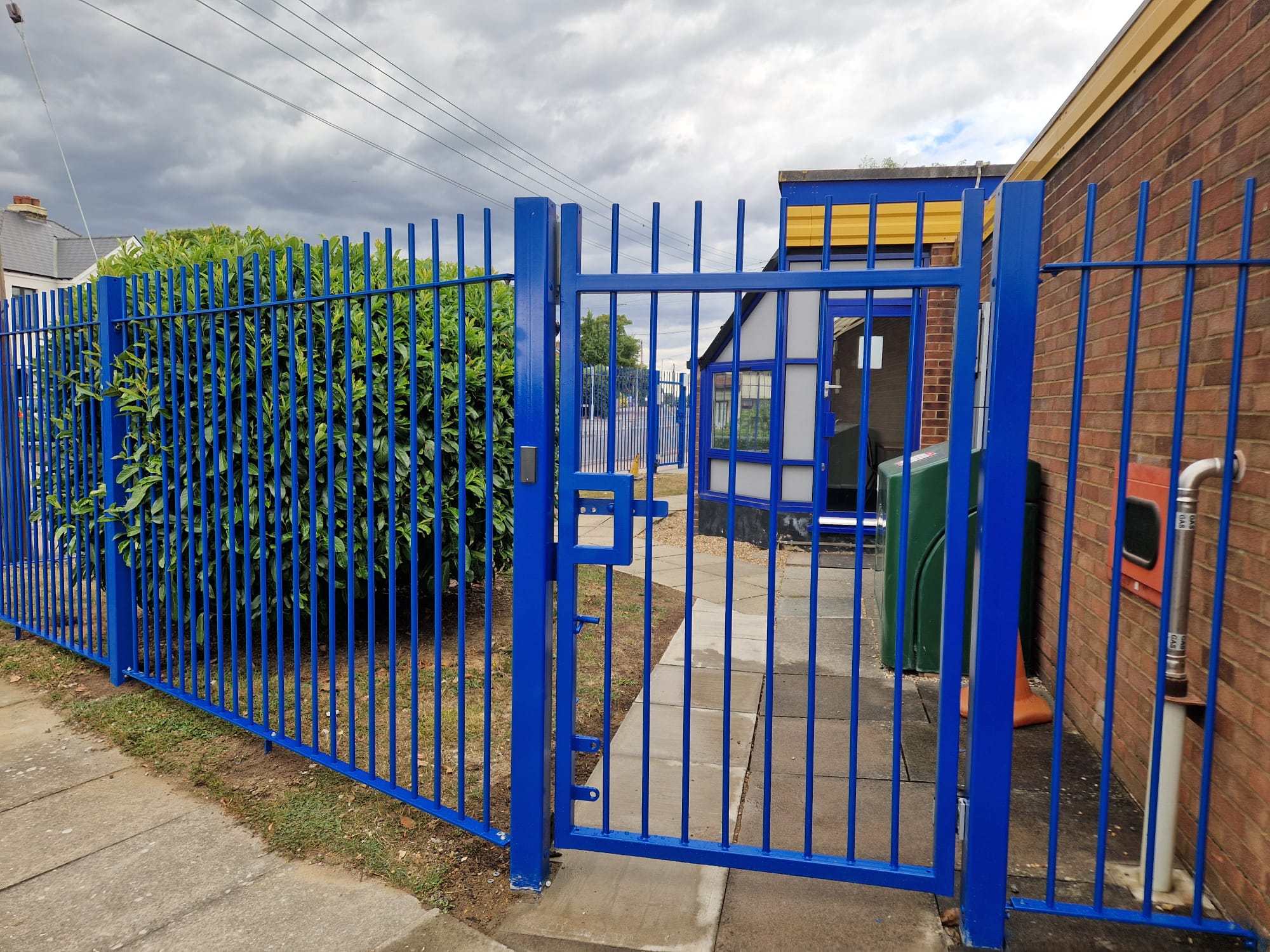 Blue steel entrance gate and matching railings at a school frontage