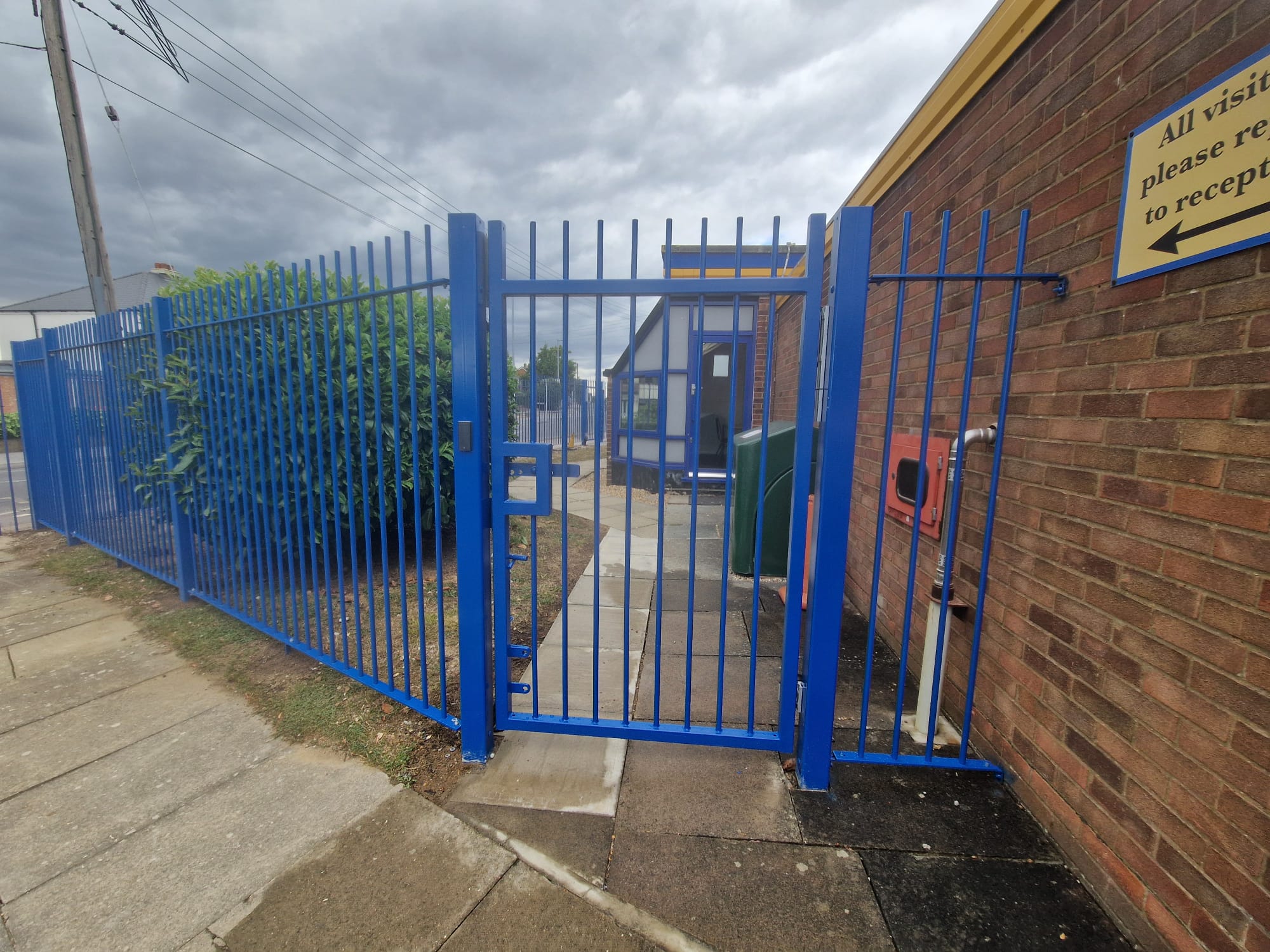 Blue vertical bar gate and railings at the school visitor reception entrance