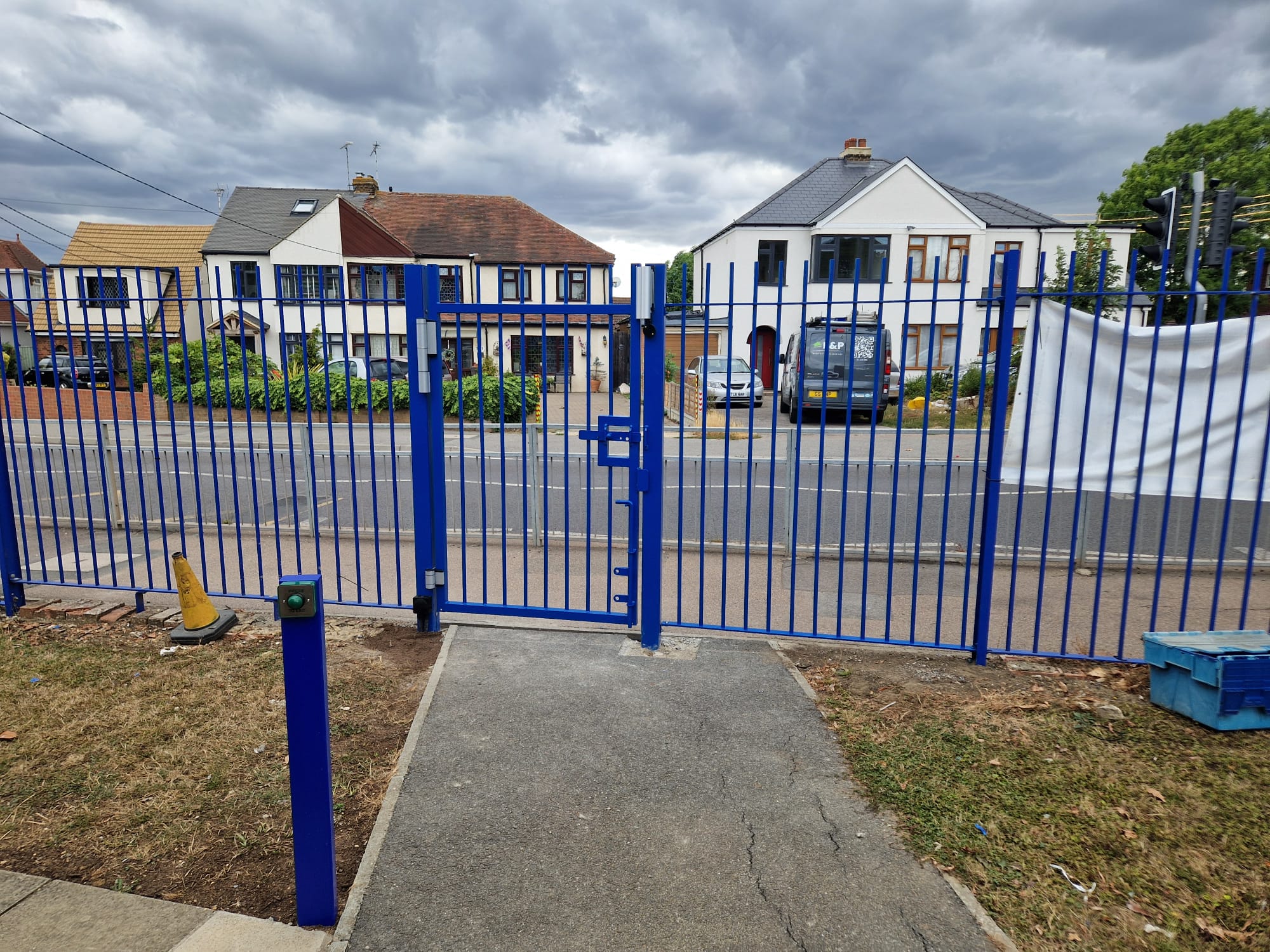 Blue double gate with push-button exit post on the school roadside boundary