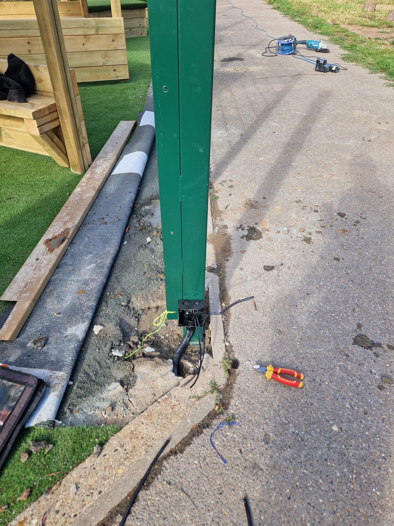 Mesh gate post set into the ground with access control cabling run to the base